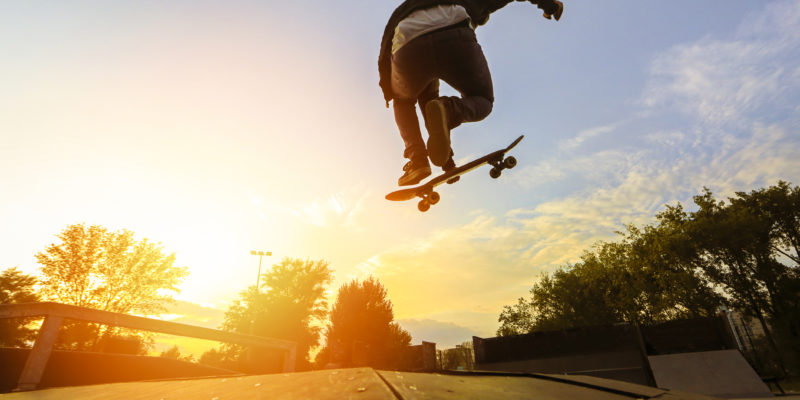 Skateboarding jumping over sunset