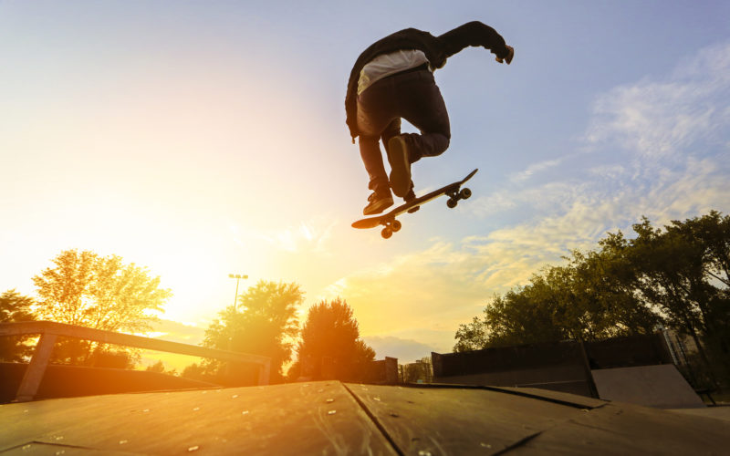 Skateboarding jumping over sunset